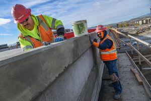 (Francisco Kjolseth  |  The Salt Lake Tribune)  Miguel Jimenez, left, and Manuel Robles do patchwork as UDOT completes partial construction of a highway-spanning bridge.