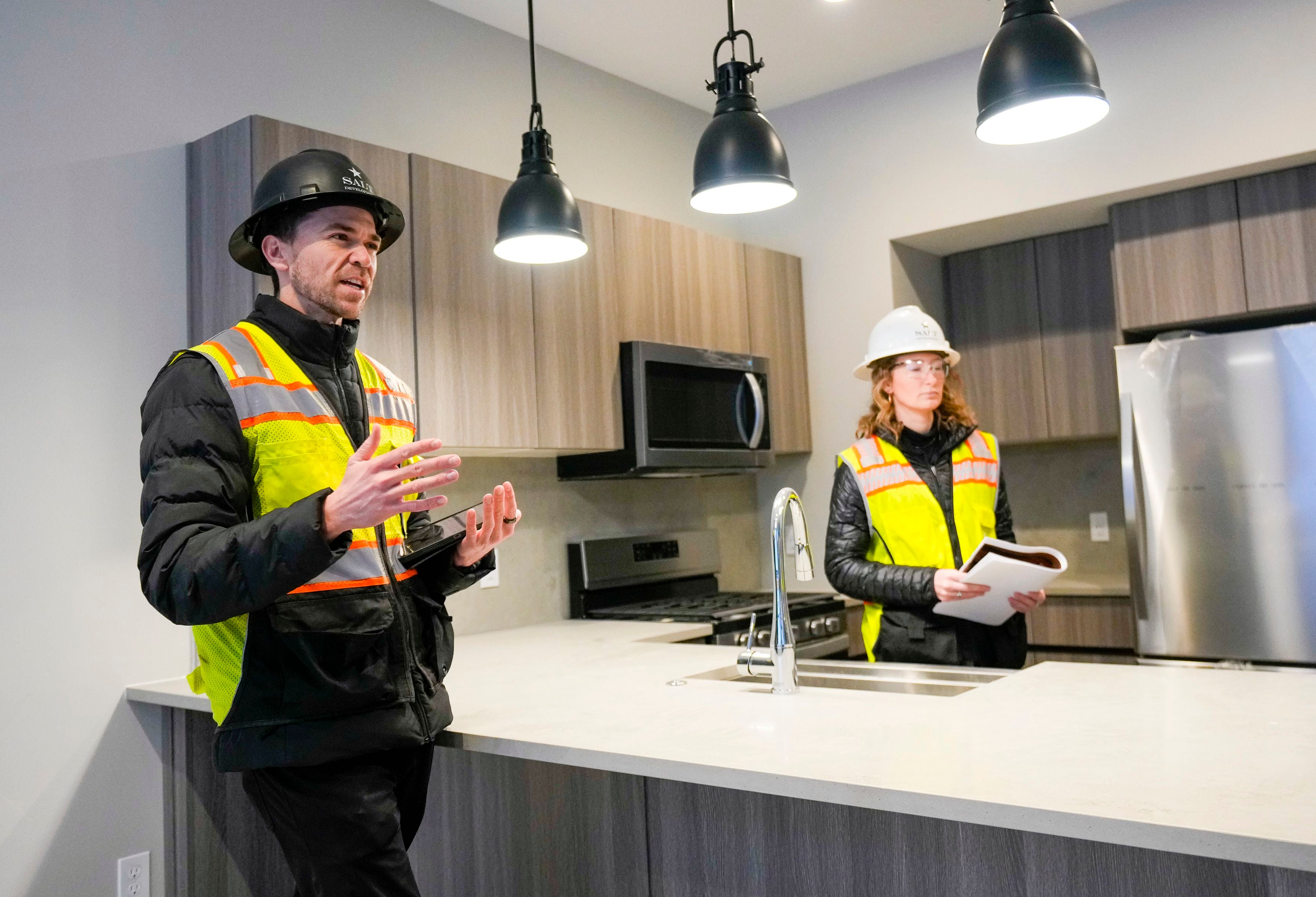 (Bethany Baker | The Salt Lake Tribune) Austin Vegh, left, the community manager for Salt Lake Crossing, speaks during a tour at Salt Lake Crossing, a new apartment complex set to open in May, in downtown Salt Lake City on Friday, March 8, 2024.