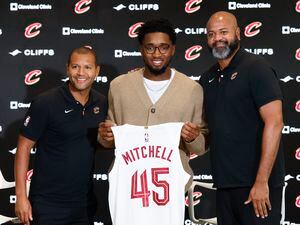 Cleveland Cavaliers guard Donovan Mitchell, center, holds up his jersey along with president of basketball operations Koby Altman, left, and head coach J.B. Bickerstaff during an NBA basketball news conference, Wednesday, Sept. 14, 2022, in Cleveland. (AP Photo/Ron Schwane)