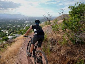 (Francisco Kjolseth | The Salt Lake Tribune) After an 1,100-foot climb, the new Parley's Pointe Trail provides expansive views of the Salt Lake Valley as a rider is treated to the view on Wednesday, Aug. 10, 2022. The 4.8-mile trail is part of the Bonneville Shoreline Trail and winds between the Parley's Trail bike path and the Arcadia trailhead on Lakeline Drive.