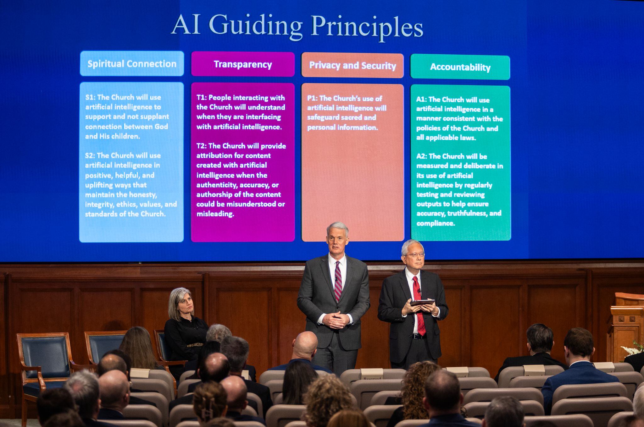 (The Church of Jesus Christ of Latter-day Saints) Latter-day Saint apostle Gerrit W. Gong, right, and John C. Pingree, left, of the Seventy spoke to church employees worldwide from the Church Office Building auditorium in Salt Lake City on Wednesday, March 13, 2024. The leaders introduced four "guiding principles" they said employees should apply to their use of A.I. technology.