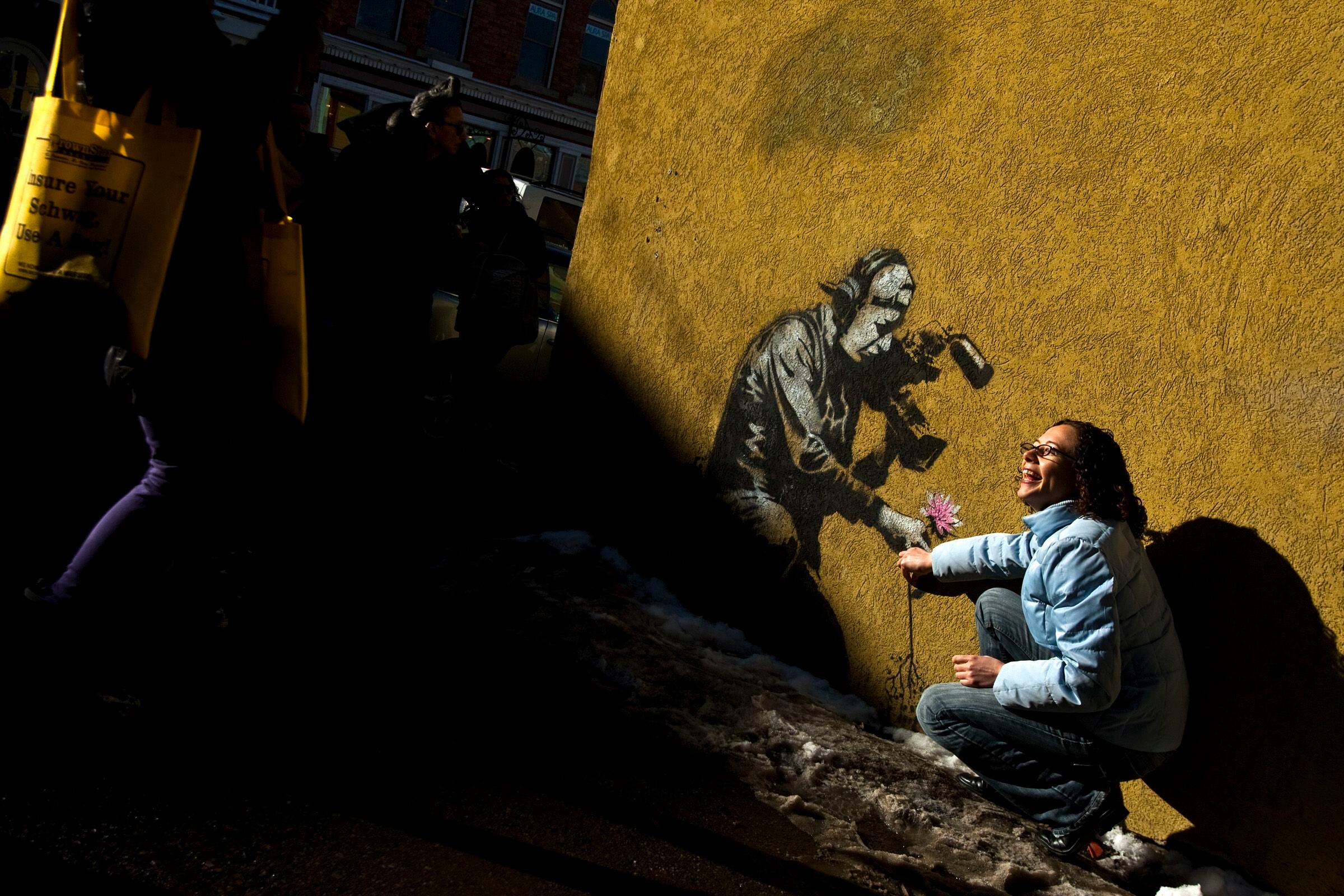 (Chris Detrick | The Salt Lake Tribune) Festivalgoers take a picture next to a Banksy art work during the Sundance Film Festival in Park City, Friday, Jan. 21, 2011.