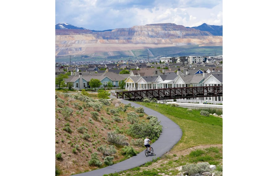 (Francisco Kjolseth | The Salt Lake Tribune) A bicyclist rounds a curve on the Oquirrh Lake Loop Trail in Daybreak, a master-planned community built with dense housing and walkability in mind.
