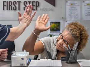 (Leah Hogsten | The Salt Lake Tribune)  Paulette Anderson, admissions coordinator for First Step House, high-fives a new tenant upon their first meeting, Oct. 4, 2022. ""Everybody who walks through this door is family," said Anderson of the workplace she said is the best job she's ever had. The facility serves over 1,200 individuals a year, who arrive with very little resources, lack of support and numerous barriers to overcome. First Step House provides all encompassing care and treatment for people diagnosed with a substance use disorder, mental health conditions, Veterans, those involved in the criminal justice system, people with low to no income, and those who have unstable or no housing.Ê