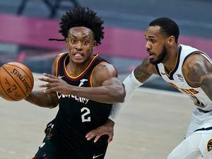 Cleveland Cavaliers' Collin Sexton, left, drives past Denver Nuggets' Monte Morris in the first half of an NBA basketball game, Friday, Feb. 19, 2021, in Cleveland. (AP Photo/Tony Dejak)