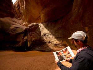 (Rick Egan | The Salt Lake Tribune) Glen Canyon Institute executive director Erik Balken compares the "Cathedral in the Desert" in Clear Creek Canyon with photos in a historical photo journal of Glen Canyon, on Monday, May 17, 2021.