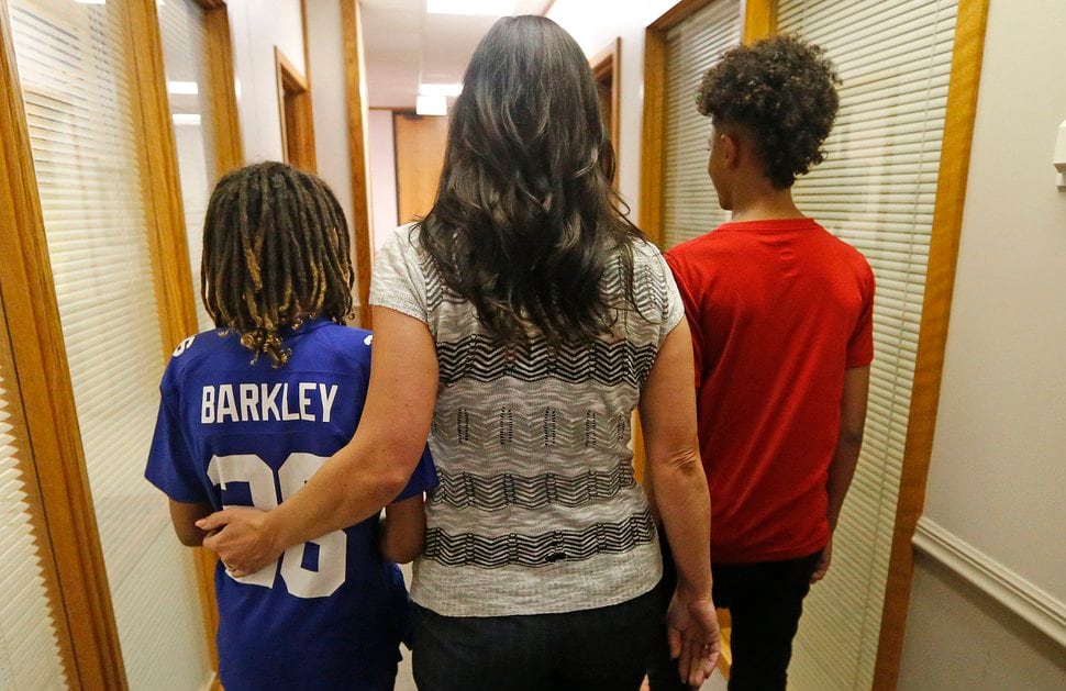 (Rick Bowmer | AP file photo) Brenda Mayes walks with her sons after a news conference Tuesday, May 7, 2019, in Salt Lake City. Mayes, sued Utah school administrators, alleging that a school bus driver trapped her older son's backpack in the door and drove away in a racially motivated event.