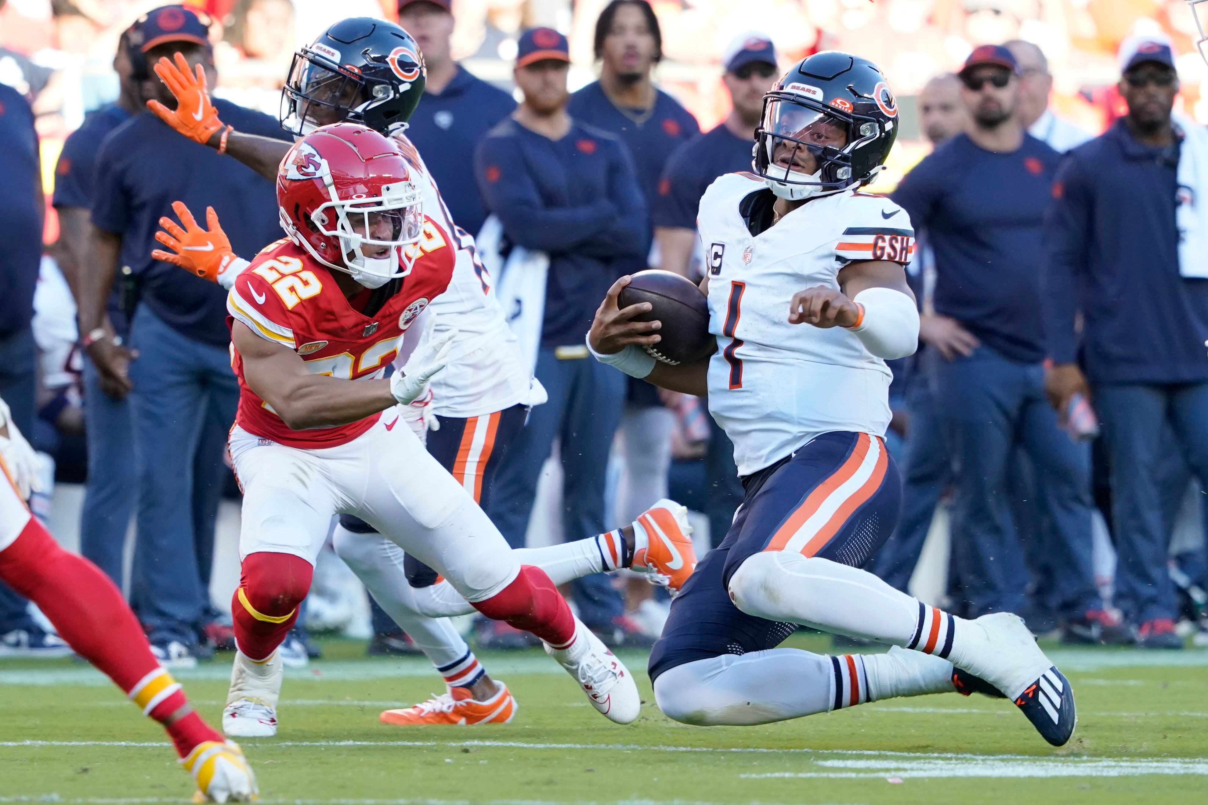 Chicago Bears quarterback Justin Fields (1) runs with the ball as Kansas City Chiefs cornerback Trent McDuffie (22) defends during the second half of an NFL football game Sunday, Sept. 24, 2023, in Kansas City, Mo. (AP Photo/Ed Zurga)