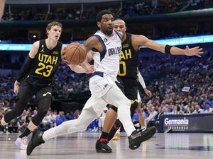 Dallas Mavericks guard Kyrie Irving, front, drives to the basket past Utah Jazz forward Lauri Markkanen (23) and Talen Horton-Tucker (0) in the first half of an NBA basketball game, Tuesday, March 7, 2023, in Dallas. (AP Photo/Tony Gutierrez)