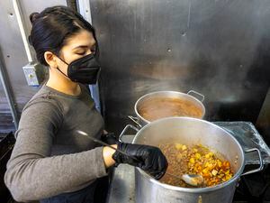 (Rick Egan | The Salt Lake Tribune) Nat Gillot, stirs a pot of Pinto Bean Soup, while volunteering with the Food Justice Coalition, on Friday, Dec. 9, 2022.