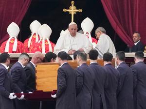 (Alessandra Tarantino | AP) Pope Francis, center, sits as the coffin of late Pope Emeritus Benedict XVI is carried during a funeral mass at St. Peter's Square in the Vatican, Thursday, Jan. 5, 2023. Benedict died at 95 on Dec. 31 in the monastery on the Vatican grounds where he had spent nearly all of his decade in retirement.