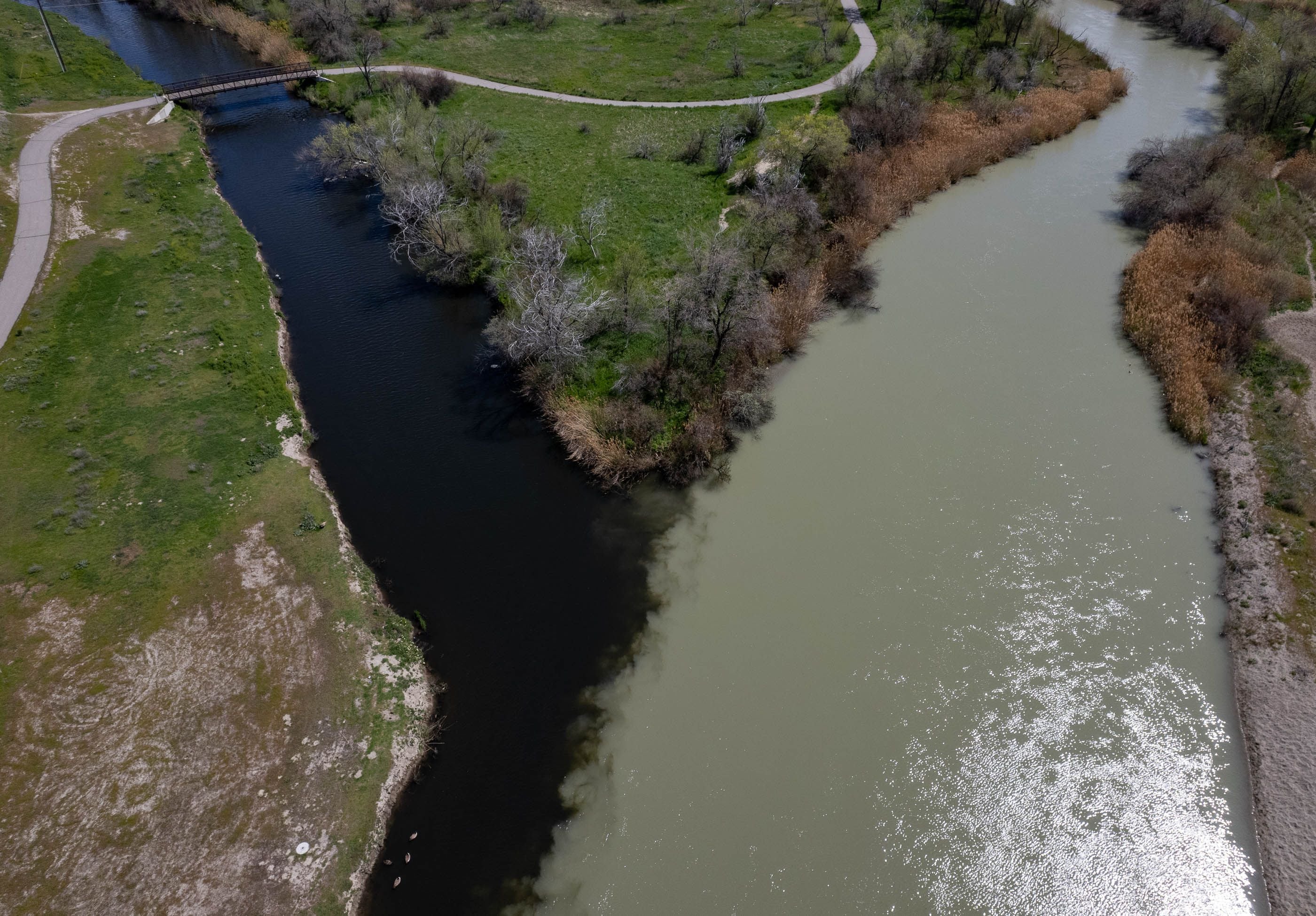 (Francisco Kjolseth | The Salt Lake Tribune) The dark waters of Mill Creek combine with the flow of the Jordan River on Wednesday, April 17, 2024.