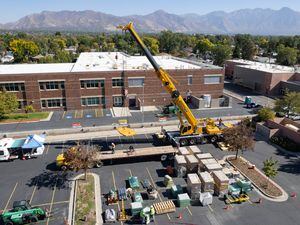 (Francisco Kjolseth | The Salt Lake Tribune) A crew begins the process of installing 510 solar panels to the roof of Whittier Elementary, on Wednesday, Oct. 12, 2022, in order to offset 60% of the school’s energy use.