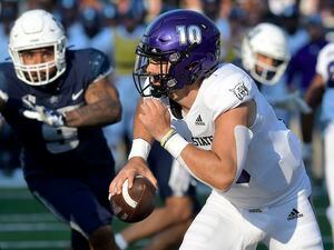 (Eli Lucero/The Herald Journal via AP) Weber State quarterback Bronson Barron (10) scrambles out of the pocket as Utah State defensive end Daniel Grzesiak (9) defends in the first half of an NCAA college football game Saturday, Sept. 10, 2022, in Logan, Utah.