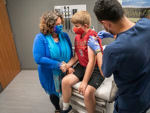 (Huntsman Cancer Institute) Deanna Kepka holds her son Jonah's hand while he gets the HPV vaccine.