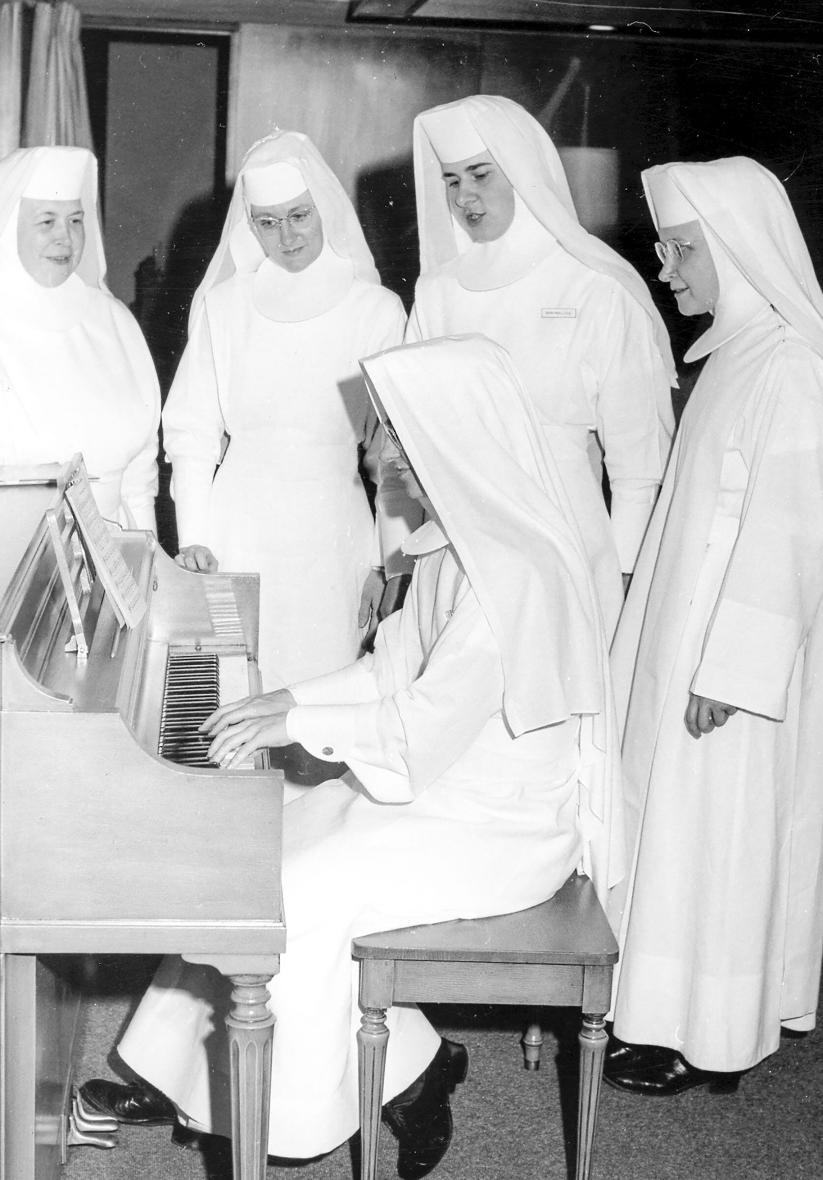 (Sisters of the Order of St. Benedict) Taking a break from their medical responsibilities, sisters at St. Benedict's Hospital in Ogden enjoy a musical interlude in their convent.