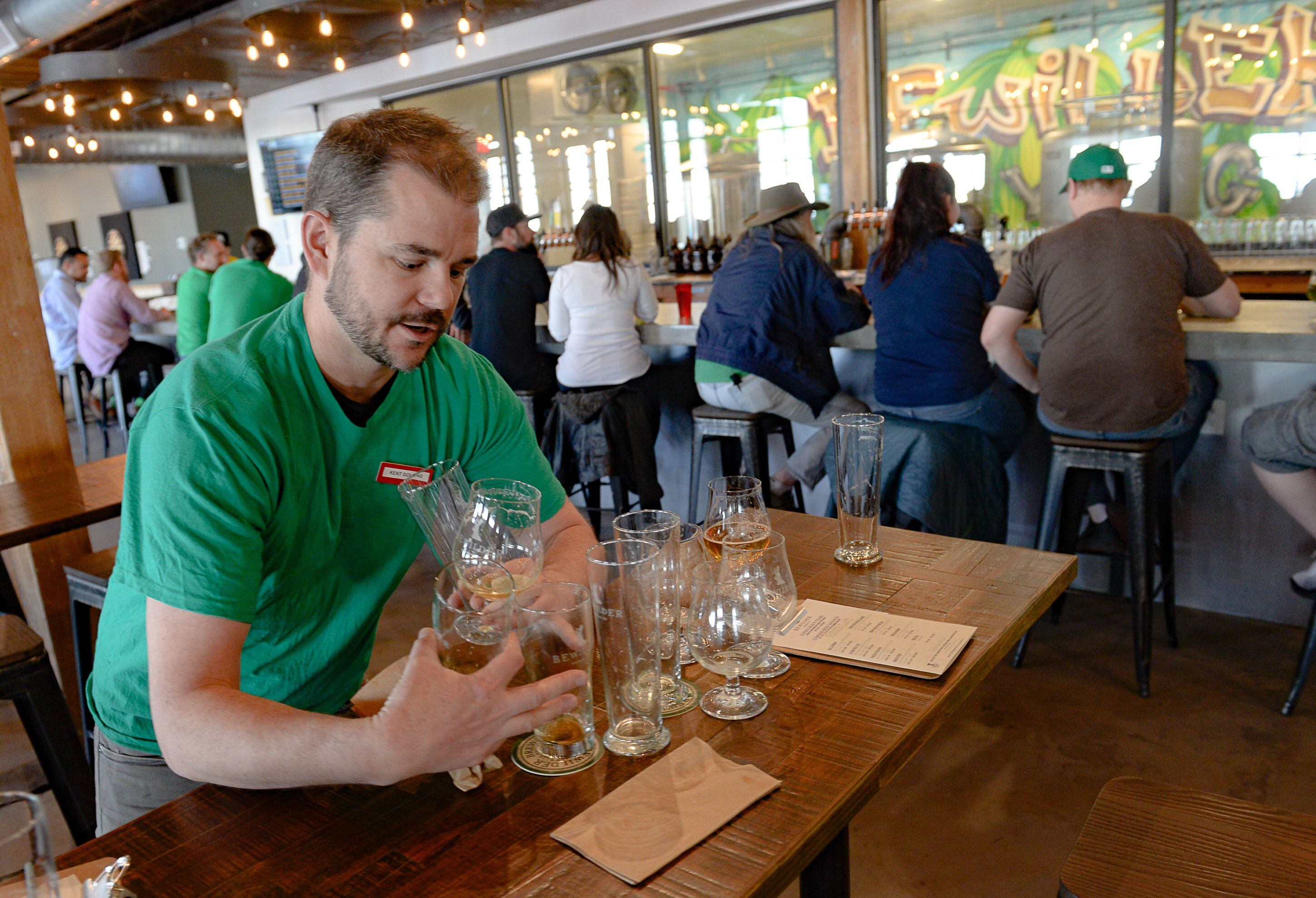 (Francisco Kjolseth | The Salt Lake Tribune) Cody McKendrick, co-owner of Bewilder Brewing Co. in Salt Lake City who says business has been down 50%, clears tables on Saturday, March 14, 2020, on a day that would have been much busier had the St. Patrick's Day parade not been cancelled. The restaurant industry has been affected by social distancing and coronavirus concerns.