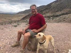 "Mystic Mike" Ginsburg sits with his dog, Stella, on bluff overlooking his property near Monroe, Utah, where the Mystic Hot Springs owner plans to build an art installation that could be seen from Interstate 70. It's a project that started thanks to rumors he was bringing Antifa to town to cause problems last Pioneer Day.