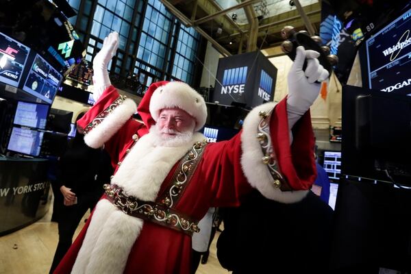 Santa Claus, from the Macy's Thanksgiving Day Parade, visits the trading floor of the New York Stock Exchange before the opening bell, Wednesday, Nov. 25, 2015. (AP Photo/Richard Drew)
