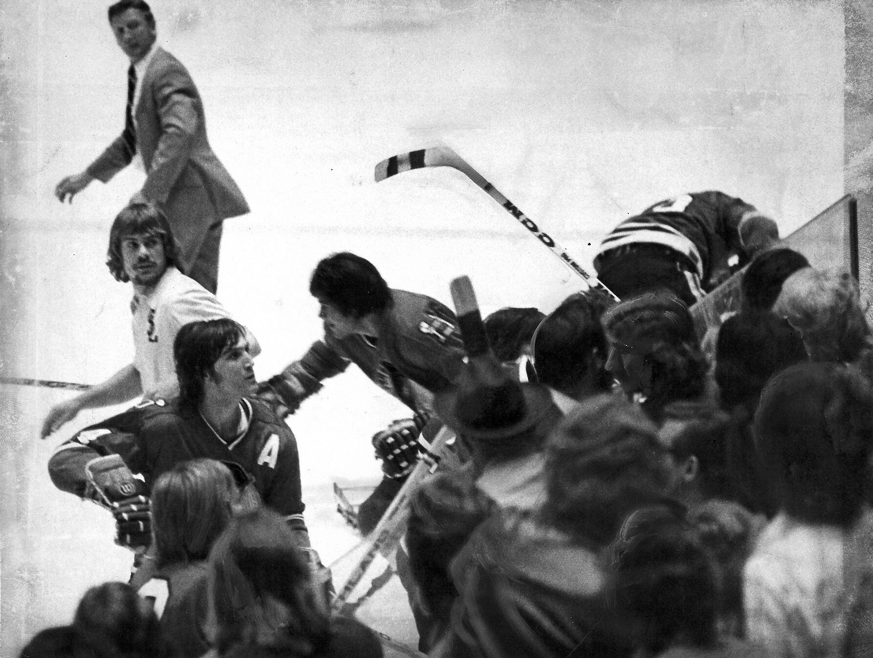 (Brian Acord) Opposing players get into a fight with fans at the Salt Palace during a Salt Lake Golden Eagles game in April of 1975.