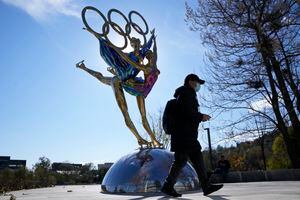 (Ng Han Guan | AP) A visitor to the Shougang Park walks past the a sculpture for the Beijing Winter Olympics in Beijing, China. China on Monday threatened to take "firm countermeasures" if the U.S. proceeds with a diplomatic boycott of February's Beijing Winter Olympic Games.