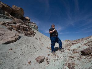(Francisco Kjolseth  | The Salt Lake Tribune) Jim Kirkland, Utah state paleontologist takes a tour of the Dalton-Wells Quarry, the centerpiece of Utah’s new Utahraptor State Park near Moab, on Monday April 12, 2021. Walking along the rocky outcropping Kirkland says “this formation has more dinosaur species than any other formation on the planet.” 