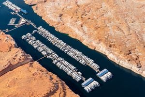 (Ecoflight) House boats are docked on a thin stretch of Lake Powell, Thursday, April 14, 2022.