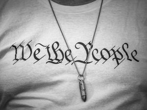 (Damon Winter | The New York Times) 

A person wears a bullet necklace over a "We the People" shirt in Miami, Jan. 6, 2022. "You cannot defend the ideal of “E pluribus unum” by deleting pluribus," writes New York Times columnist Bret Stephens.