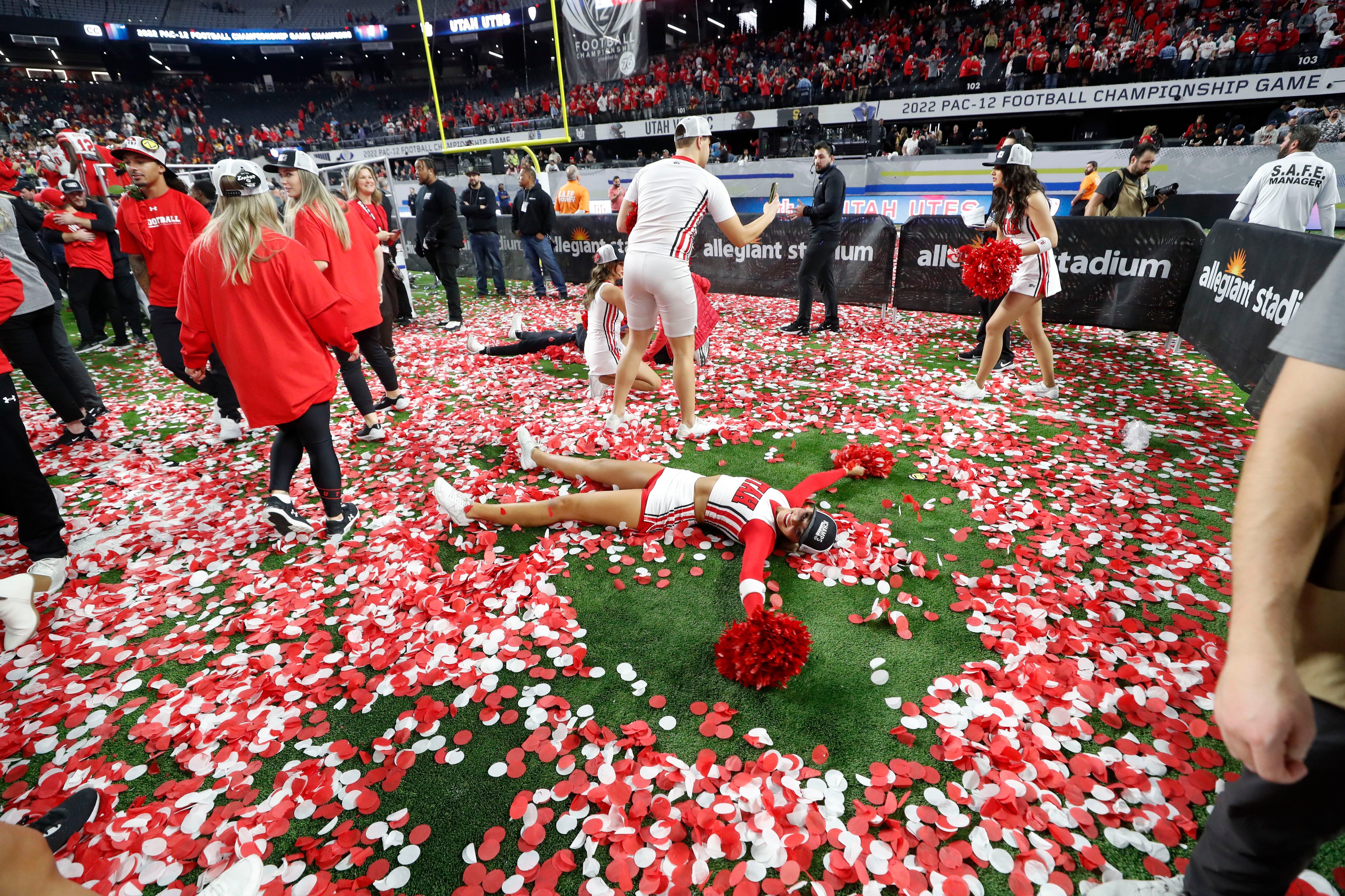 A Utah cheerleader makes a confetti angel after Utah defeated Southern California in the Pac-12 Conference championship NCAA college football game Friday, Dec. 2, 2022, in Las Vegas. (AP Photo/Steve Marcus)
