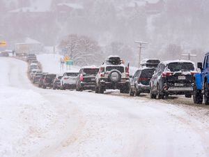 (Francisco Kjolseth | The Salt Lake Tribune) A long line of cars forms near Little Cottonwood Canyon during the snow storm on Wednesday, Feb. 22, 2023.