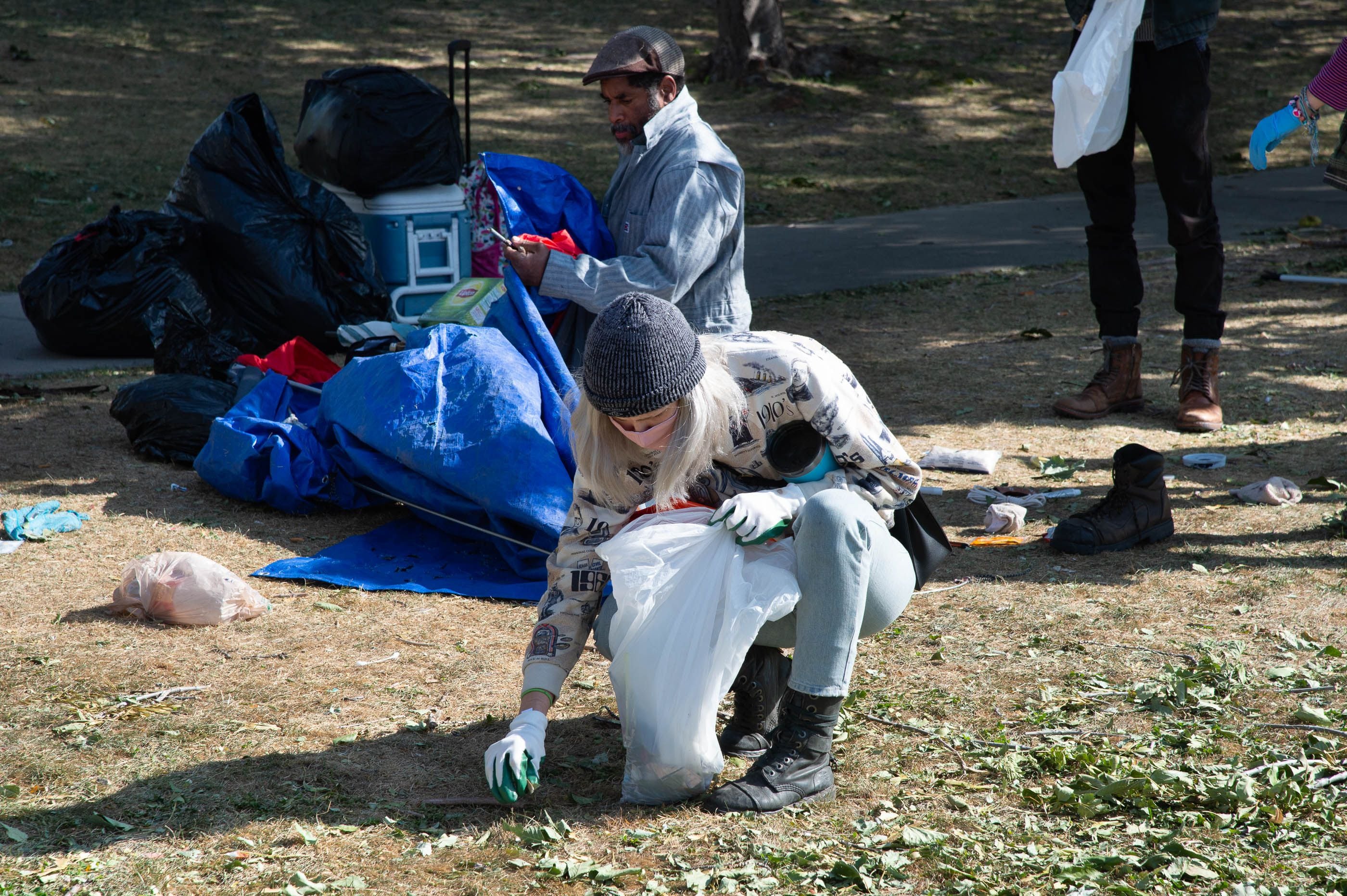 (Francisco Kjolseth  |  The Salt Lake Tribune) Homeless advocate volunteers lend their support by cleaning up trash as the Salt Lake County Health Department, backed by police, force a clean up of homeless camps near Taufer Park in Salt Lake City on Thursday, Sept. 10, 2020.