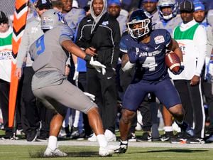 Utah State running back Calvin Tyler Jr. (4) runs with the ball as Memphis linebacker Geoffrey Cantin-Arku (9) defends during the first half of the First Responders Bowl NCAA college football game, Tuesday, Dec. 27, 2022, in Dallas. (AP Photo/Sam Hodde)