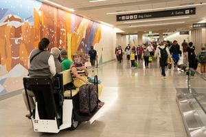 (Rick Egan | The Salt Lake Tribune) Travelers ride a cart through the tunnel to the South Concourse, at the Salt Lake International Airport, on Thursday, June 3, 2021.