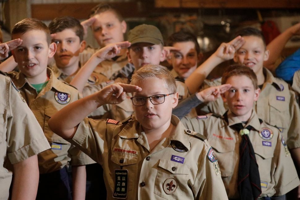 (Rick Bowmer | The Associated Press) Boy Scouts salute during their meeting, in Kaysville on Thursday, Dec. 12, 2019,