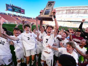 (Francisco Kjolseth | The Salt Lake Tribune) Herriman's Trevor Walk (7) hoists the championship trophy after his game winning goal came with two seconds left on the clock as the team celebrates their 6A State Soccer Championship title over Davis at Rio Tinto Stadium, Wednesday, May 25, 2022. Herriman defeated Davis 1-0.