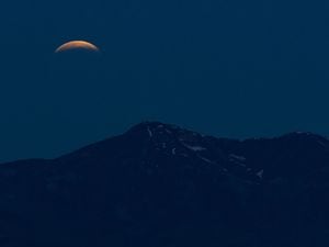 (Francisco Kjolseth | The Salt Lake Tribune) A red blood supermoon lunar eclipse sets over the Oquirrh Mountains early Wednesday, May 26, 2021.