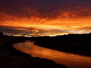 (Francisco Kjolseth | The Salt Lake Tribune) The rising sun ignites the Colorado River with color at the North Wash take out in October of 2021 offering the only nearby option for boaters as low Lake Powell reservoir levels closed Hite Marina just down river in the early 2000s. 