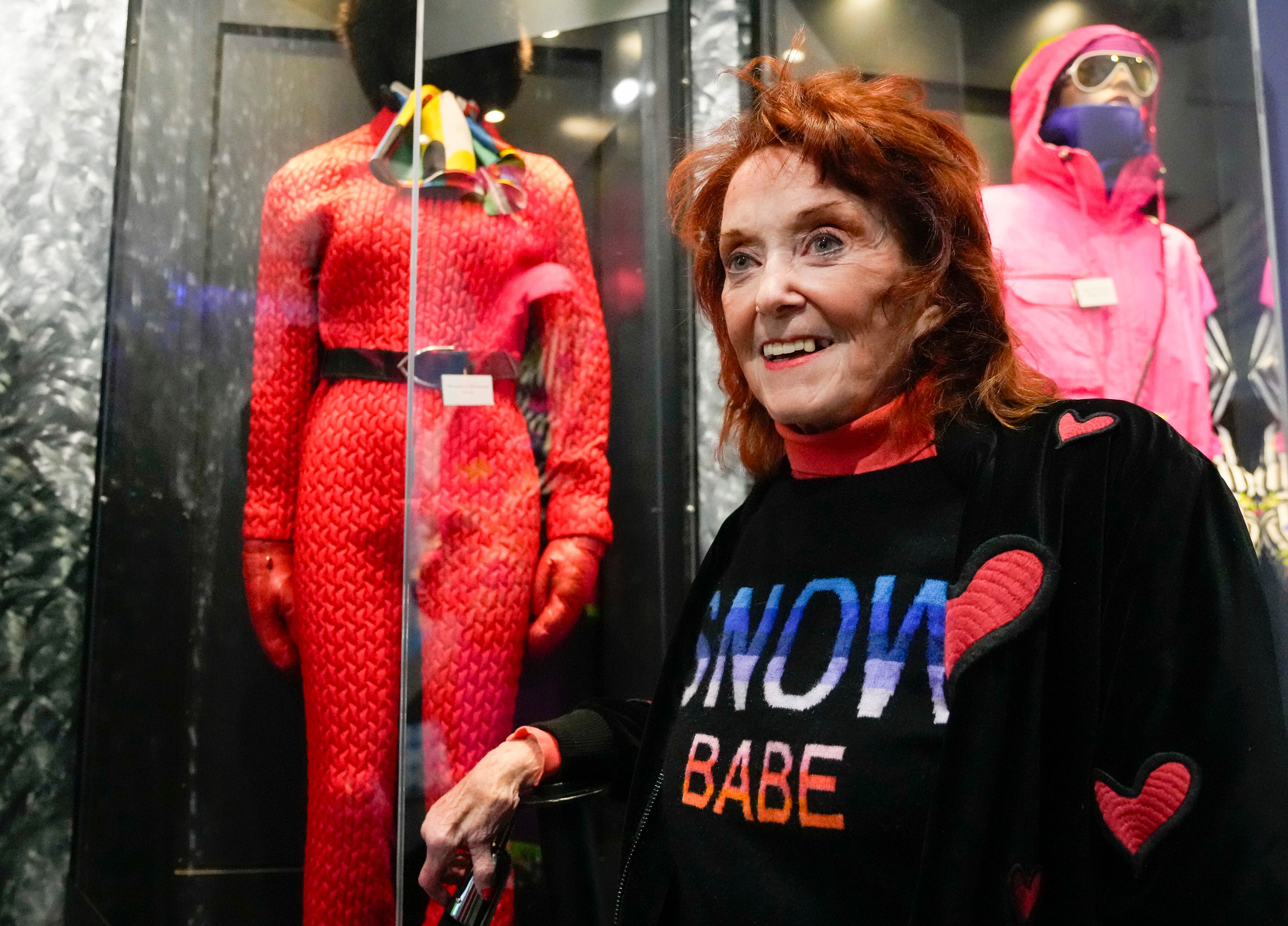 (Bethany Baker  |  The Salt Lake Tribune) Barbara Alley Simon, sometimes referred to as the "First Lady of Ski Fashion," stands in front of some of her favorite designs displayed in an exhibit at the Alf Engen Museum at Utah Olympic Park in Park City on Wednesday, March 20, 2024.