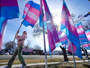 (Francisco Kjolseth | The Salt Lake Tribune) Abby Thornton, 9, helps put up a line of transgender flags in front of the Utah Pride Center in Salt Lake City on Saturday, March 18, 2023, as part of Transgender Day of Visibility on March 31. 
