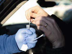 (Rachel Rydalch | The Salt Lake Tribune) EMT Charles Ledbetter, delivers a Covid test to a patient in their car in Salt Lake City on Thursday, Feb. 3, 2022.