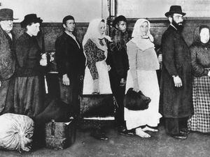 (AP) In this undated file photo, immigrants who arrived at Ellis Island in New York wait in line to begin immigration proceedings.