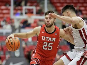 Utah guard Rollie Worster, left, controls the ball while defended by Washington State guard Dylan Darling during the first half of an NCAA college basketball game, Sunday, Dec. 4, 2022, in Pullman, Wash. (AP Photo/Young Kwak)