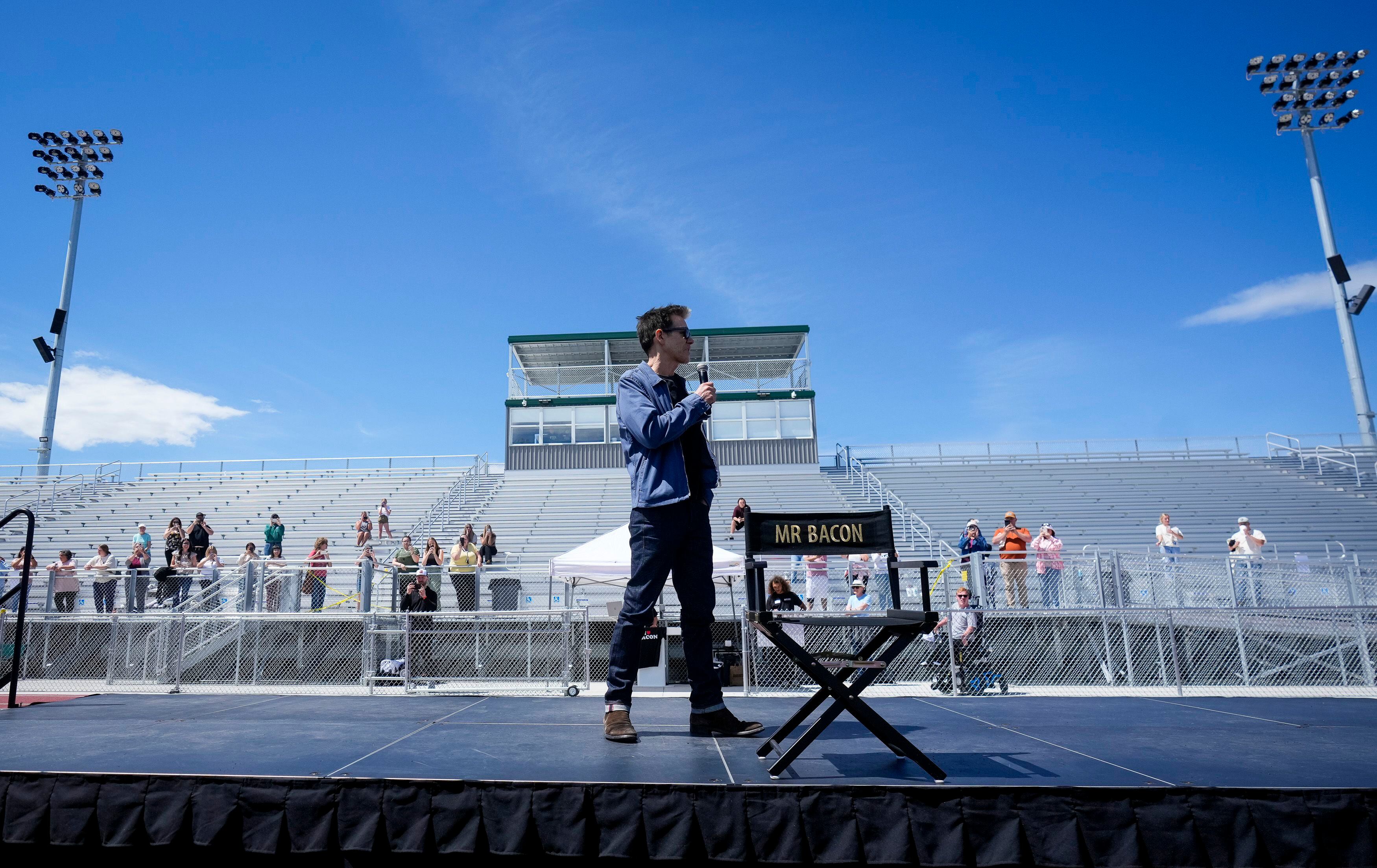 (Bethany Baker  |  The Salt Lake Tribune) Kevin Bacon speaks on stage during a charity event to commemorate the 40th anniversary of the movie "Footloose" on the football field of Payson High School in Payson on Saturday, April 20, 2024.