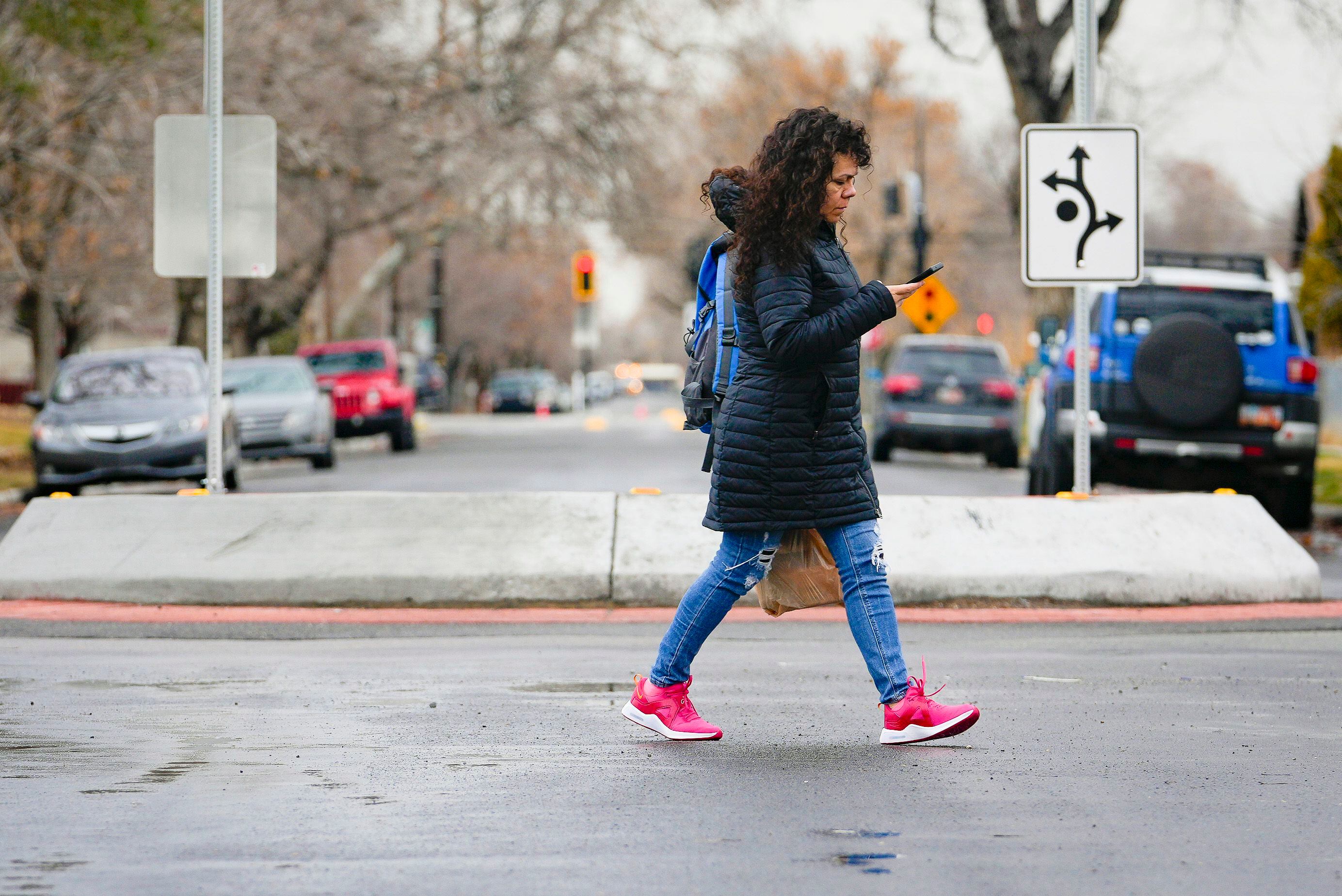 (Bethany Baker | The Salt Lake Tribune) A woman crosses the street near a roundabout at the intersection of 500 North and 1300 West in Salt Lake City on Tuesday, Feb. 20, 2024.