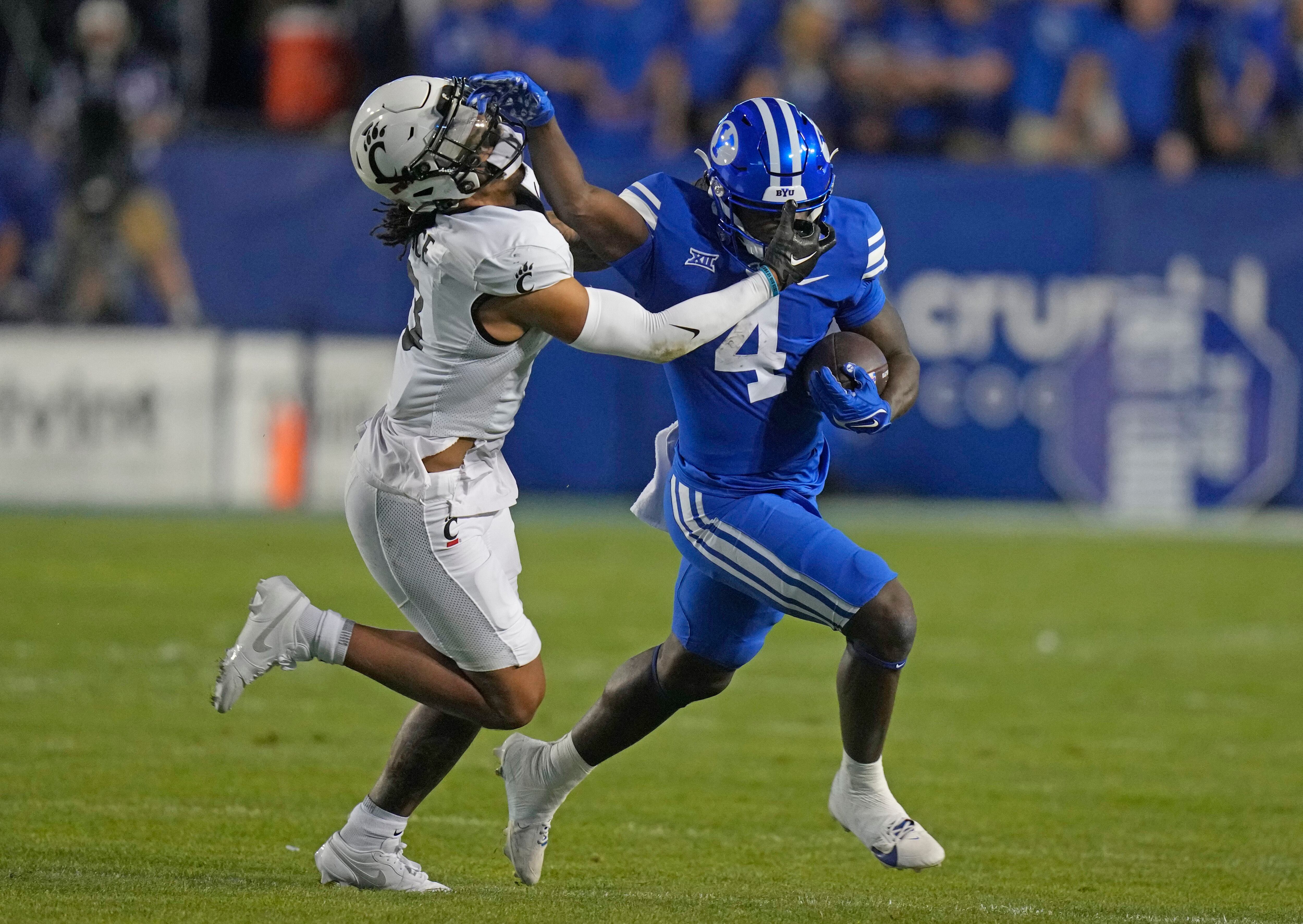 (Rick Bowmer | AP) BYU running back Miles Davis (4) stiff-arms Cincinnati safety Deshawn Pace during the first half of an NCAA college football game Friday, Sept. 29, 2023, in Provo.