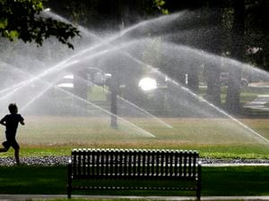 Steve Griffin  |  The Salt Lake TribuneSprinklers cool down a runner at Liberty Park in Salt Lake City Thursday July 20, 2017.