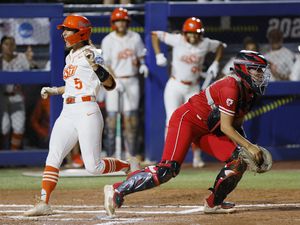 Oklahoma State's Kiley Naomi (5) scores past Utah catcher Kendall Lundberg, right, during the first inning of an NCAA softball Women's College World Series game Friday, June 2, 2023, in Oklahoma City. (AP Photo/Nate Billings)