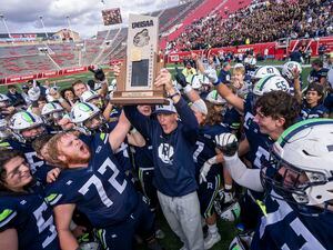 (Rick Egan | The Salt Lake Tribune) Ridgeline head coach Travis Cox hoists the trophy above his head, as he celebrates the Riverhawks 4A Championship, after defeating the Dixie Flyers, at Rice-Eccles Stadium, on Friday, Nov. 12, 2021.
