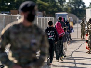 (Andrew Harnik | AP) Afghan refugees walk through an Afghan refugee camp at Joint Base McGuire Dix Lakehurst, N.J., Monday, Sept. 27, 2021. Afghan community groups and resettlement agencies prepare to help 765 new arrivals to Utah in the coming weeks.