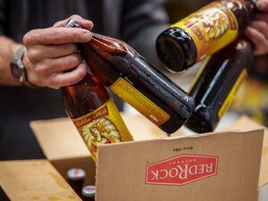 (Trent Nelson  |  The Salt Lake Tribune) A worker packages bottles of the Golden Halo Blonde Ale at Red Rock Brewery in Salt Lake City on Wednesday, Feb. 1, 2023. The ale is 5.8% ABV, which means Red Rock can't serve it on tap in Utah, and must serve it in bottles or cans.